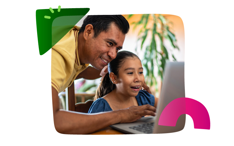 Smiling Latino man stands behind a smiling Latino girl sitting in front of a laptop, his hand on the laptop’s touchpad