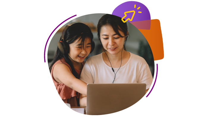 Asian woman and young girl with headphones smile while looking at a laptop