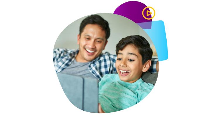 dad and son smiling while looking at a tablet