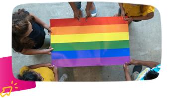 5 kids holding a rainbow flag